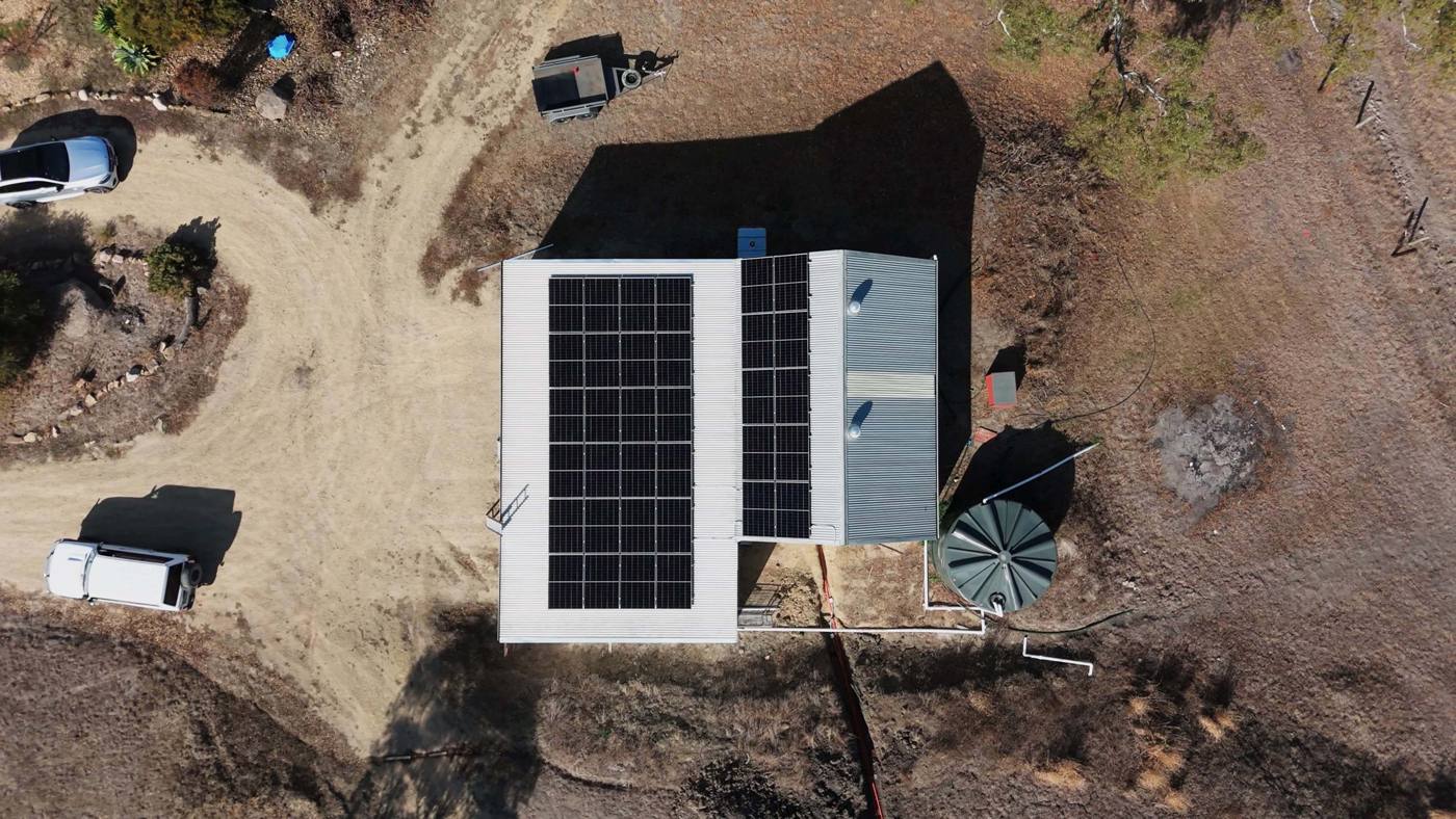 Top-down view of an off-grid shed roof solar array and water tank, an NG Elec build