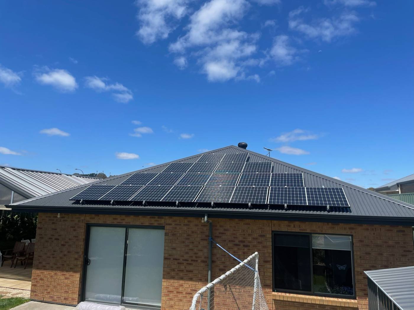 Rear of a brick home with a solar array on a dark roof