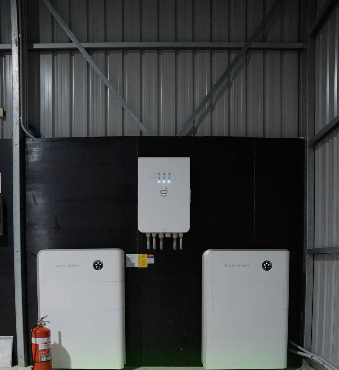 Twin Sigenergy batteries and an inverter mounted in a shed