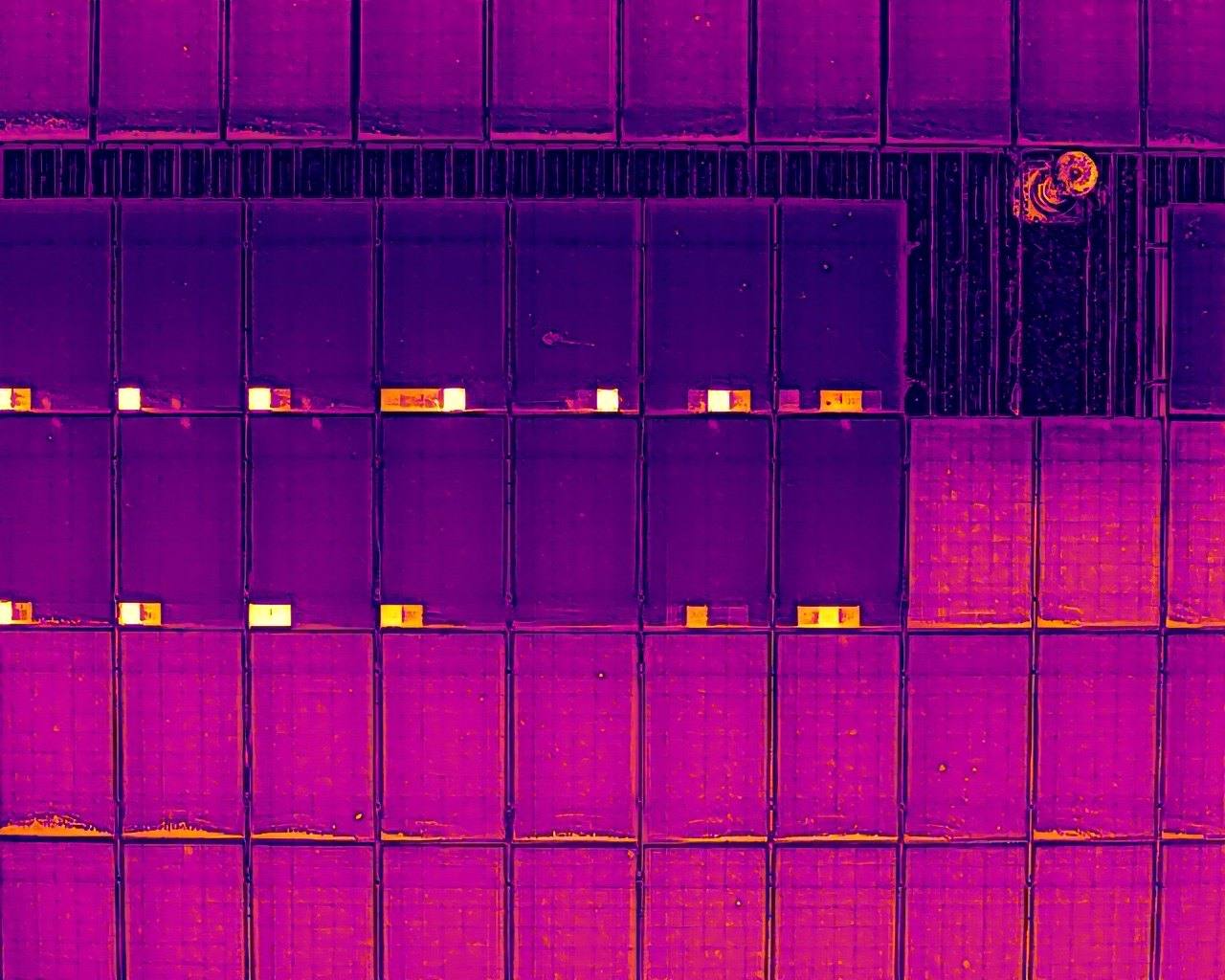 Thermal image of solar panels showing bright hot spots on damaged cells