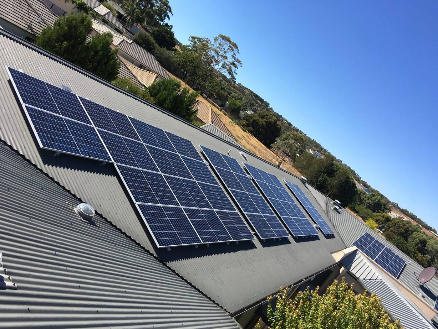 Rows of solar panels on a grey corrugated roof in the Adelaide foothills