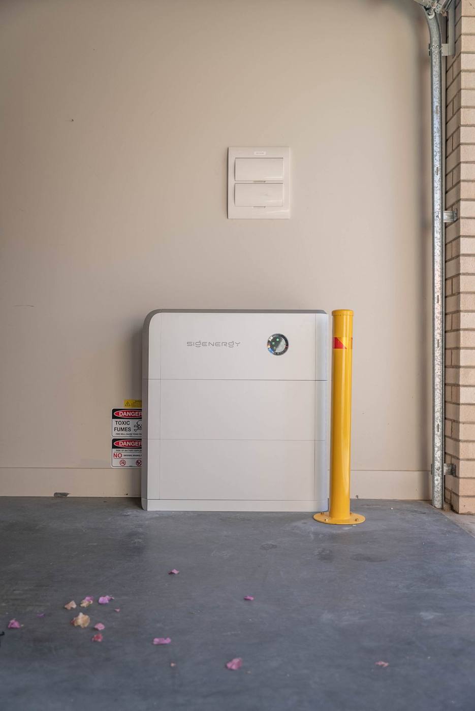 Sigenergy home battery installed in a garage with a protective bollard